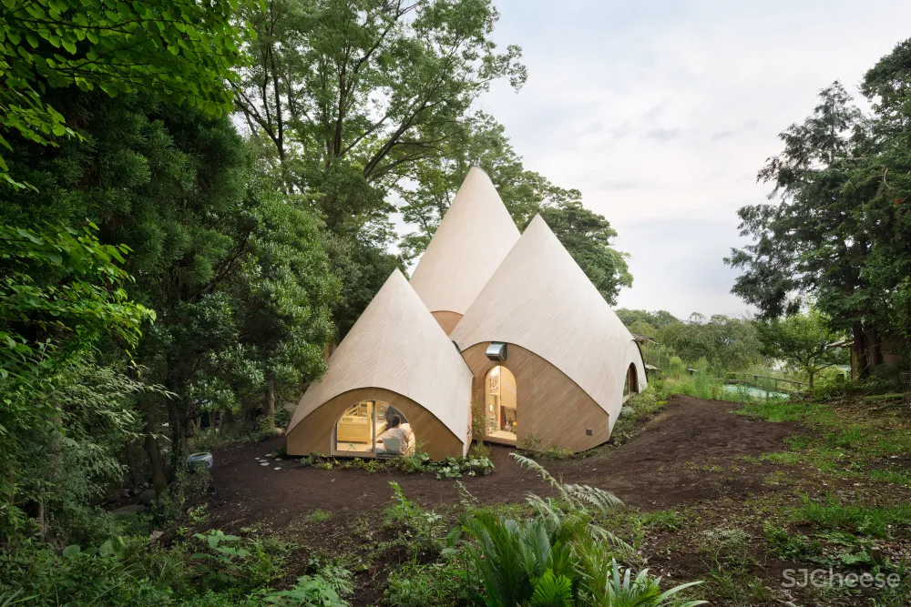 Teepee-shaped buildings by Issei Suma house community kitchen and pool
