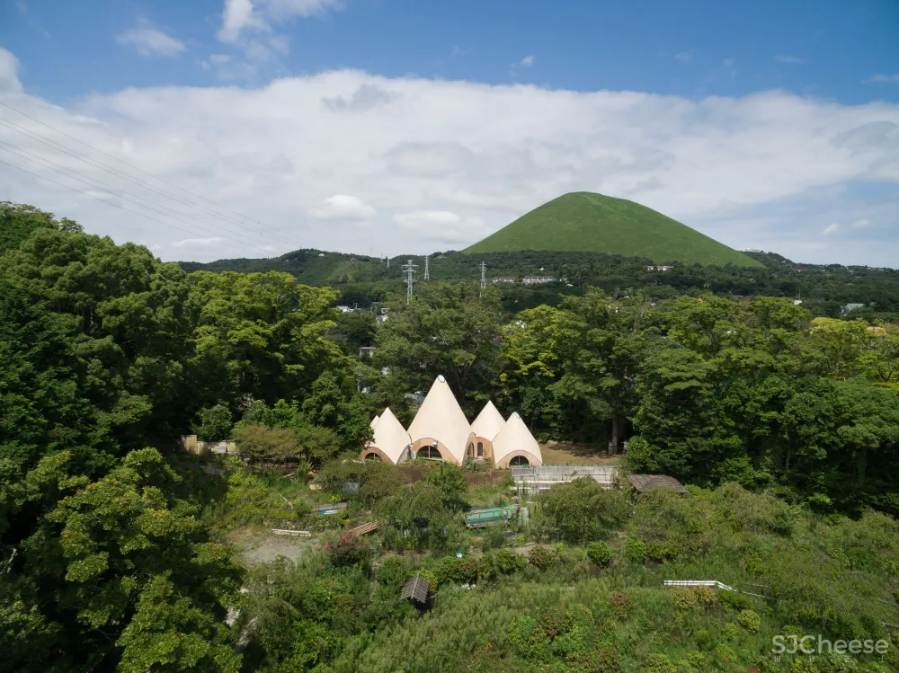 Teepee-shaped buildings by Issei Suma house community kitchen and pool